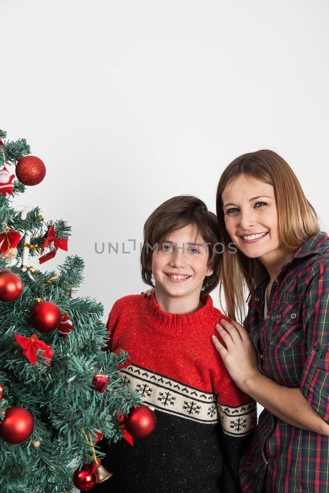 Boy and his mom smiling beside the christmas tree by ifilms