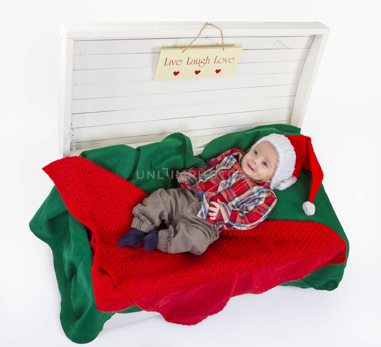 cute baby boy with a santa claus hat in wooden box on white background