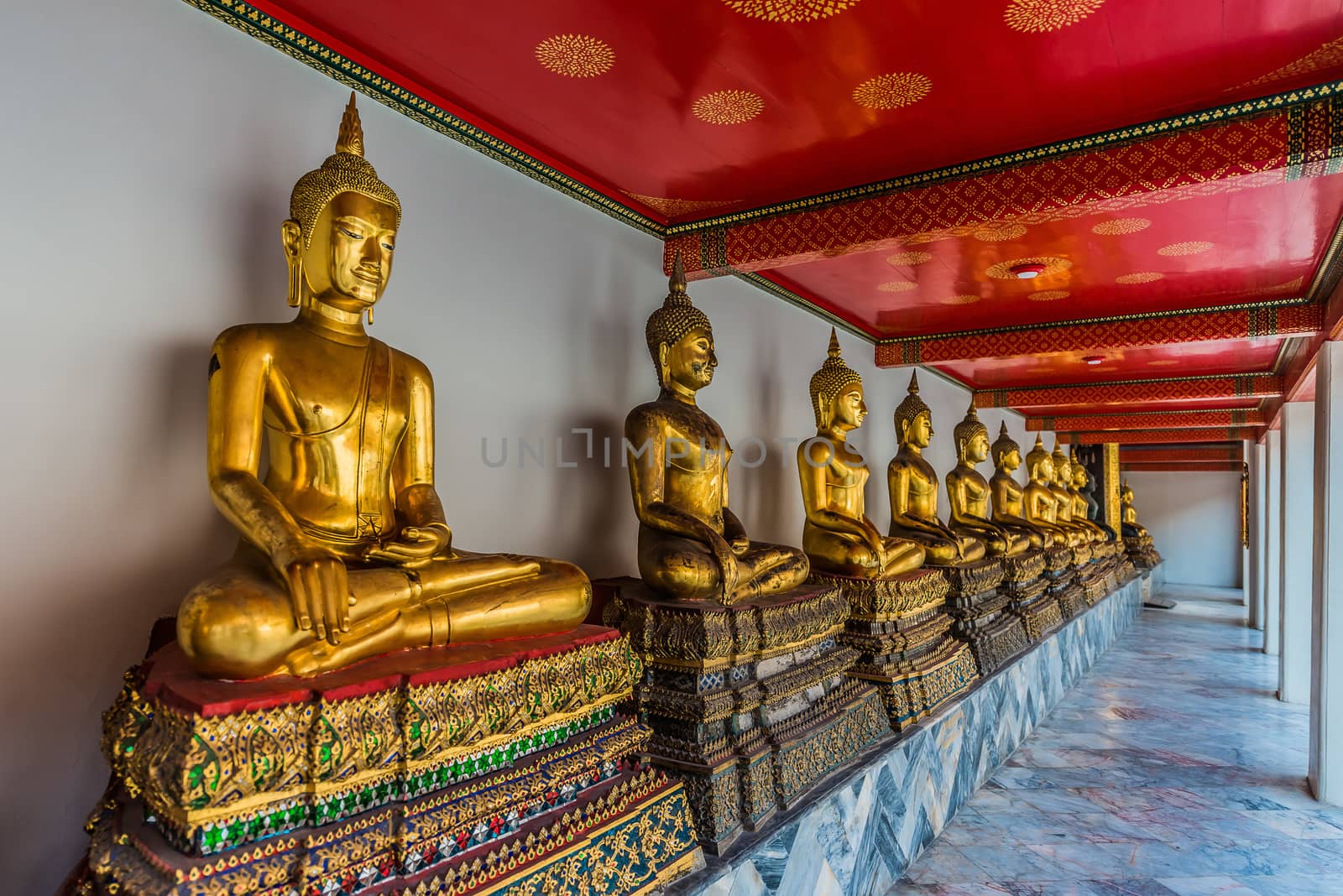 aligned golden buddha statues Wat Pho temple bangkok Thailand by PIXSTILL