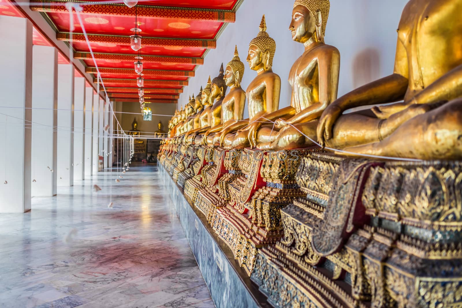 aligned golden buddha statues Wat Pho temple bangkok Thailand by PIXSTILL