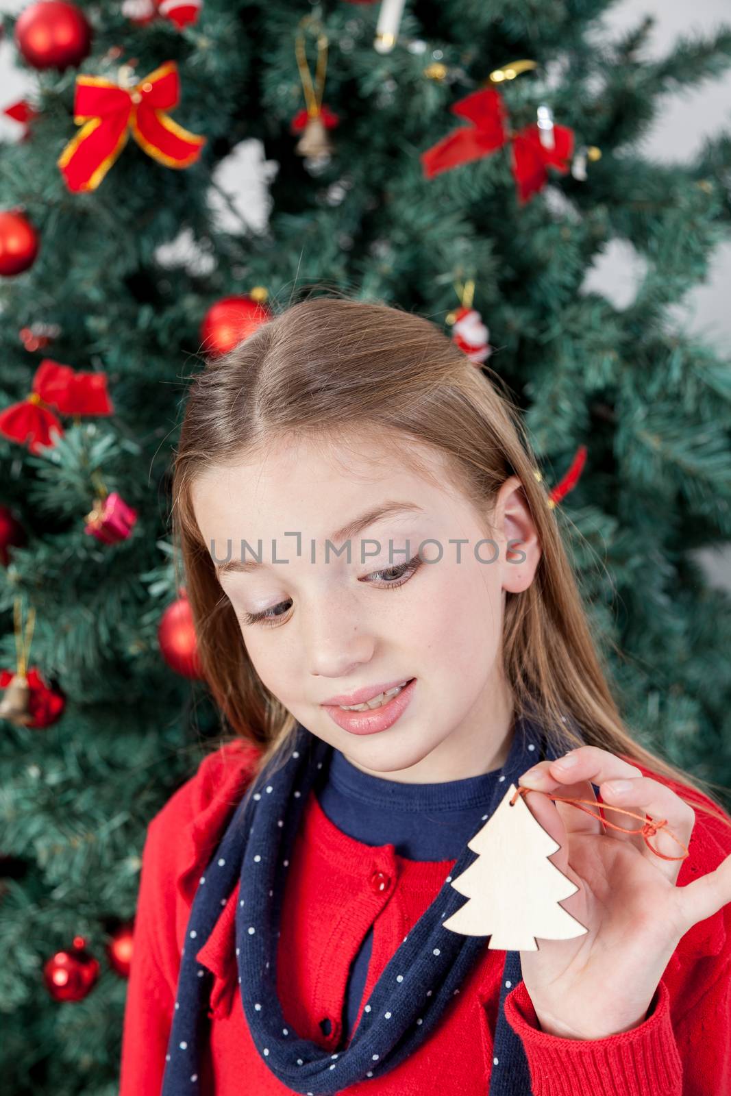 Girl holding a ornament of the christmas tree by ifilms