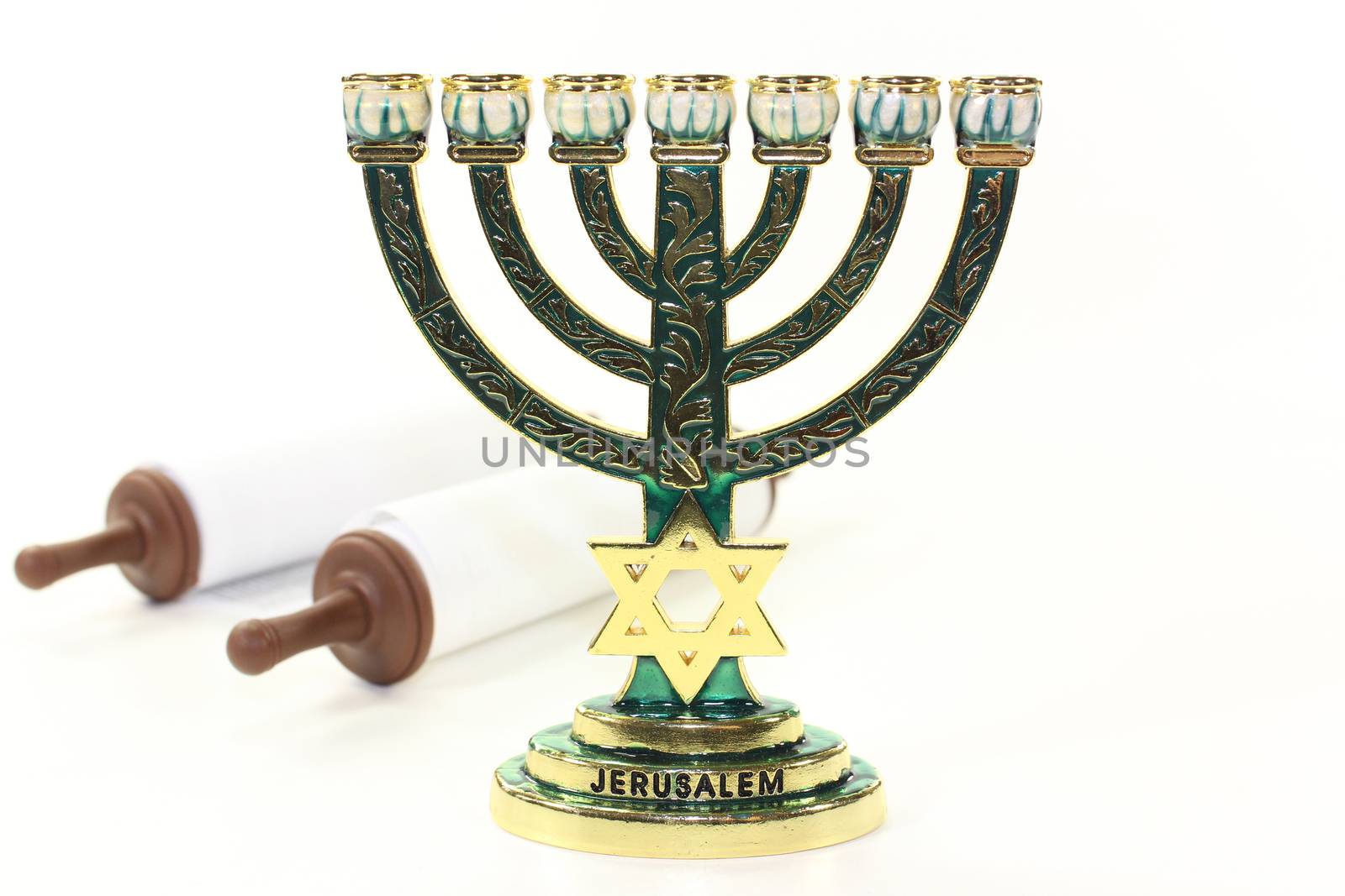 Jewish candlestick and Torah scroll in front of white background