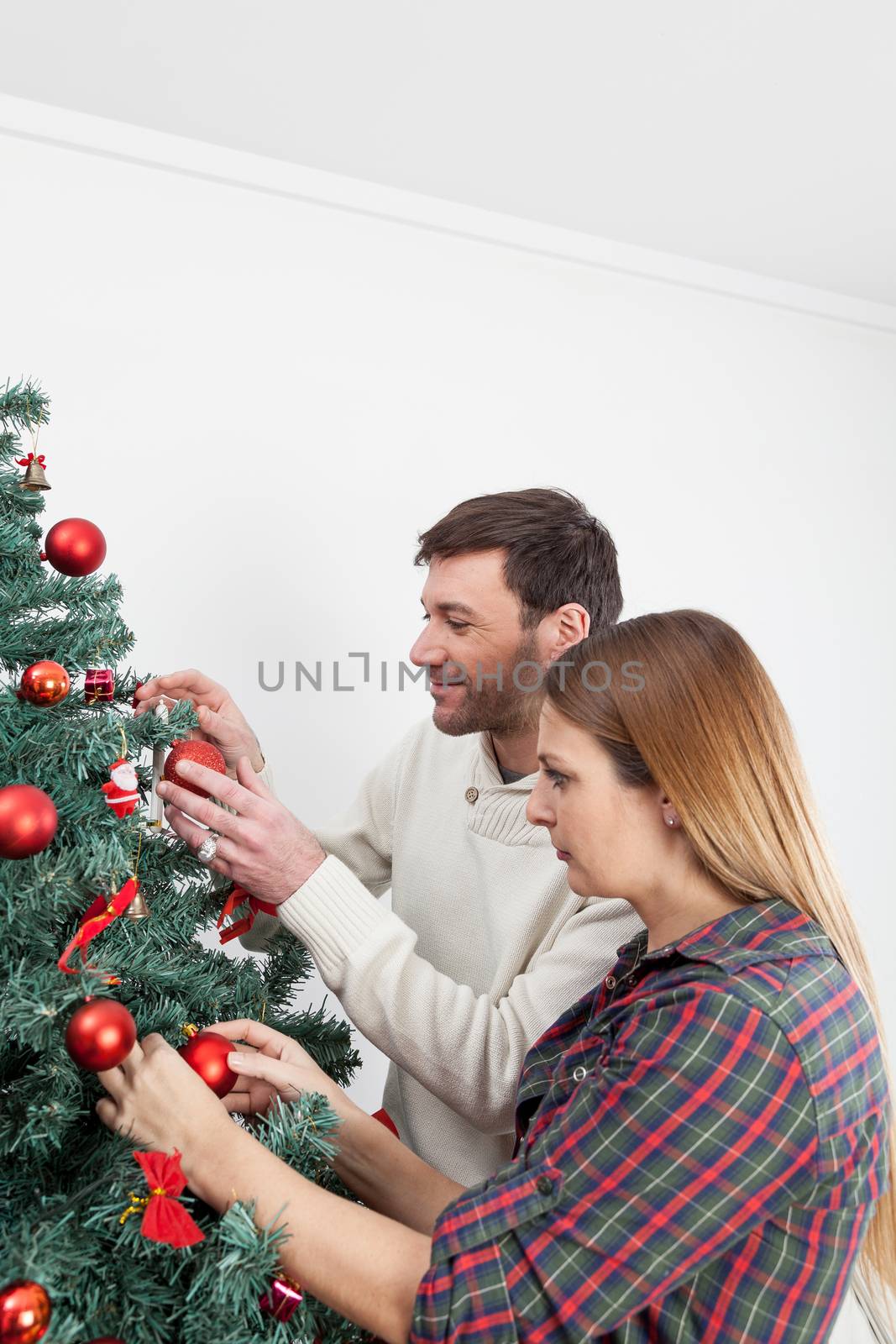 Couple decorating the christmas tree by ifilms
