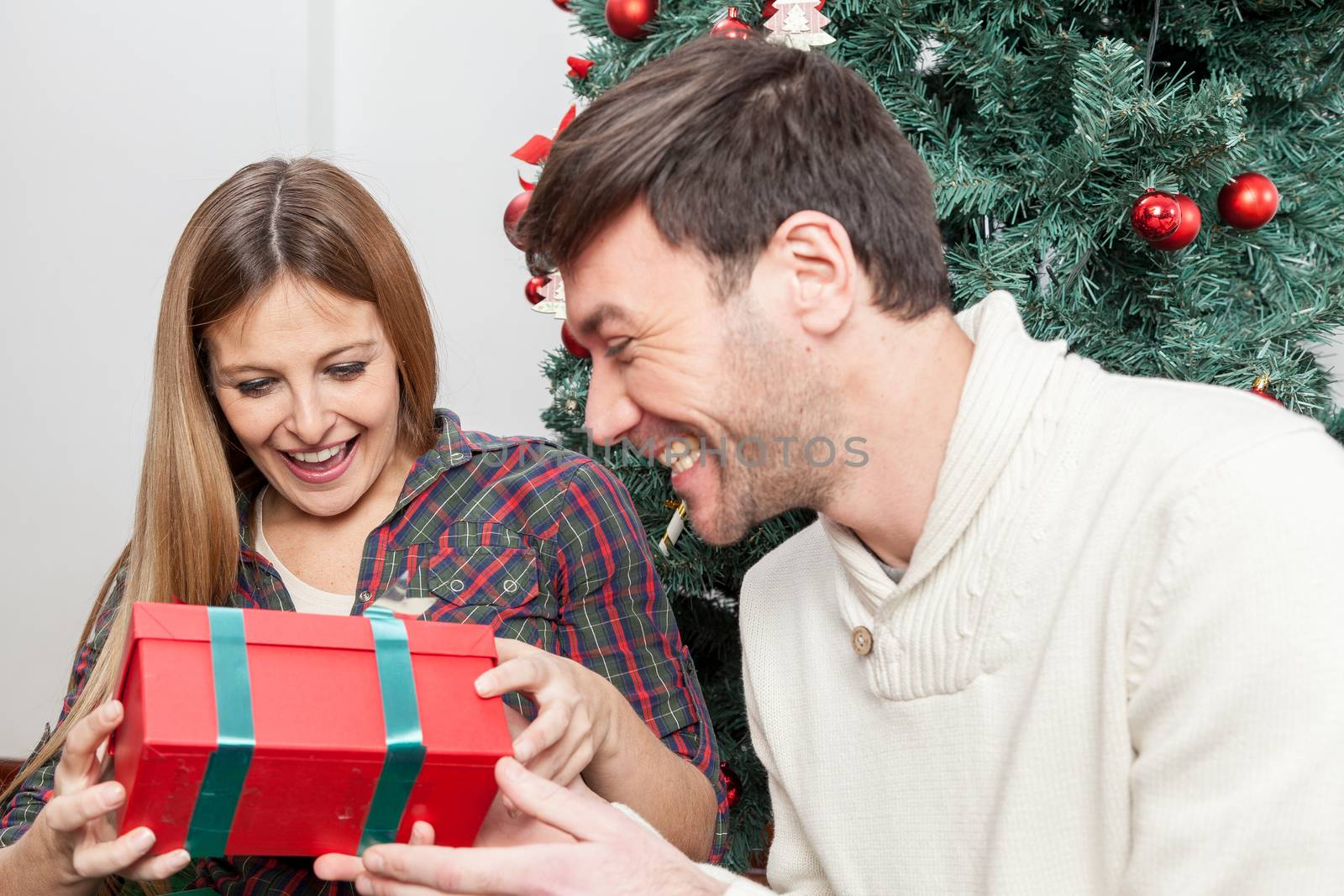 Fun couple opening a christmas gift by ifilms