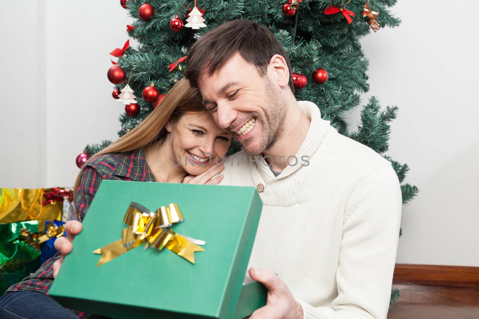 Fun couple opening a christmas gift by ifilms