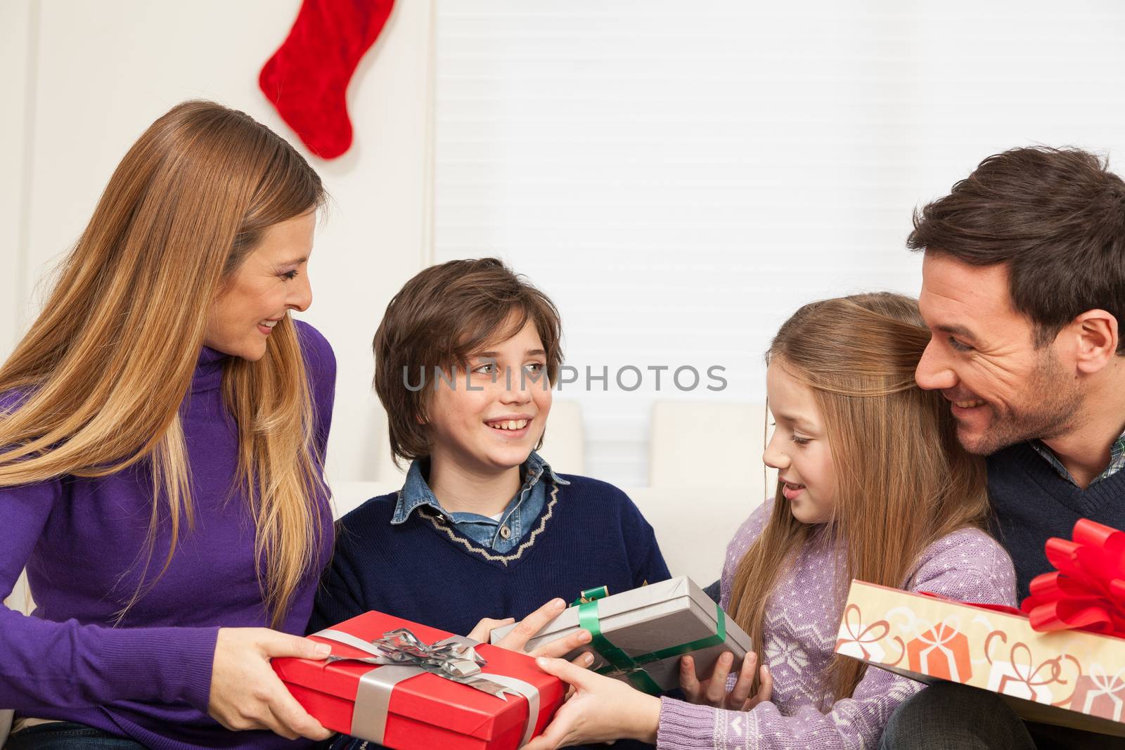 10-12, 30-35, 8-10, adult, boy, caucasian, celebrating, celebration, child, children, christmas, colour, couple, daughter, enjoying, enjoyment, family, father, four, gift, gifts, girl, happiness, happy, holding, holiday, home, horizontal, house, indoors, interior, leisure, lifestyle, living, look, looking, love, loving, mature, men, model, mother, occasion, old, parent, people, present, presents, property, releases, room, sitting, smile, smiling, sofa, son, special, surprise, together, two, women, year, years