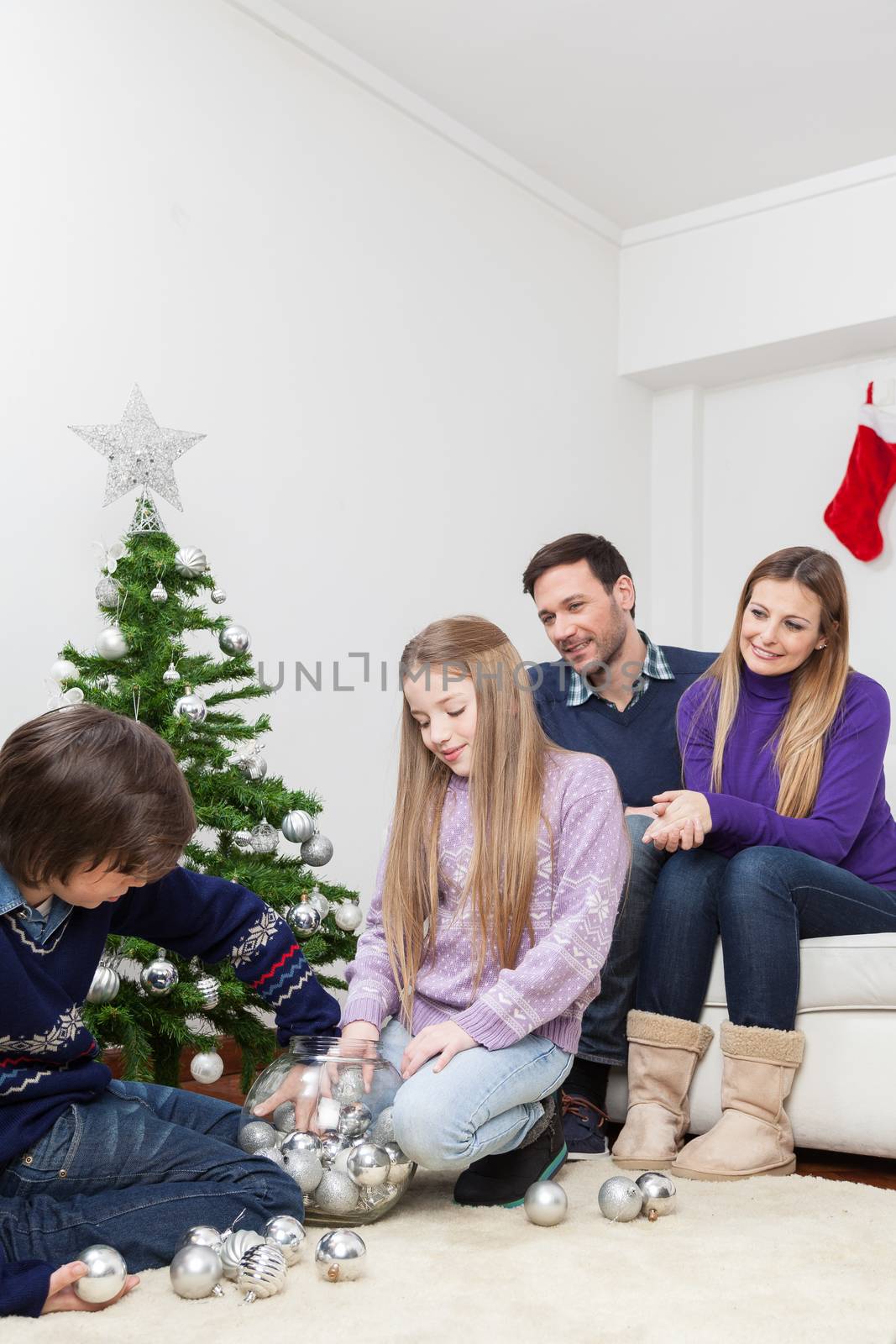 Family preparing the christmas tree by ifilms