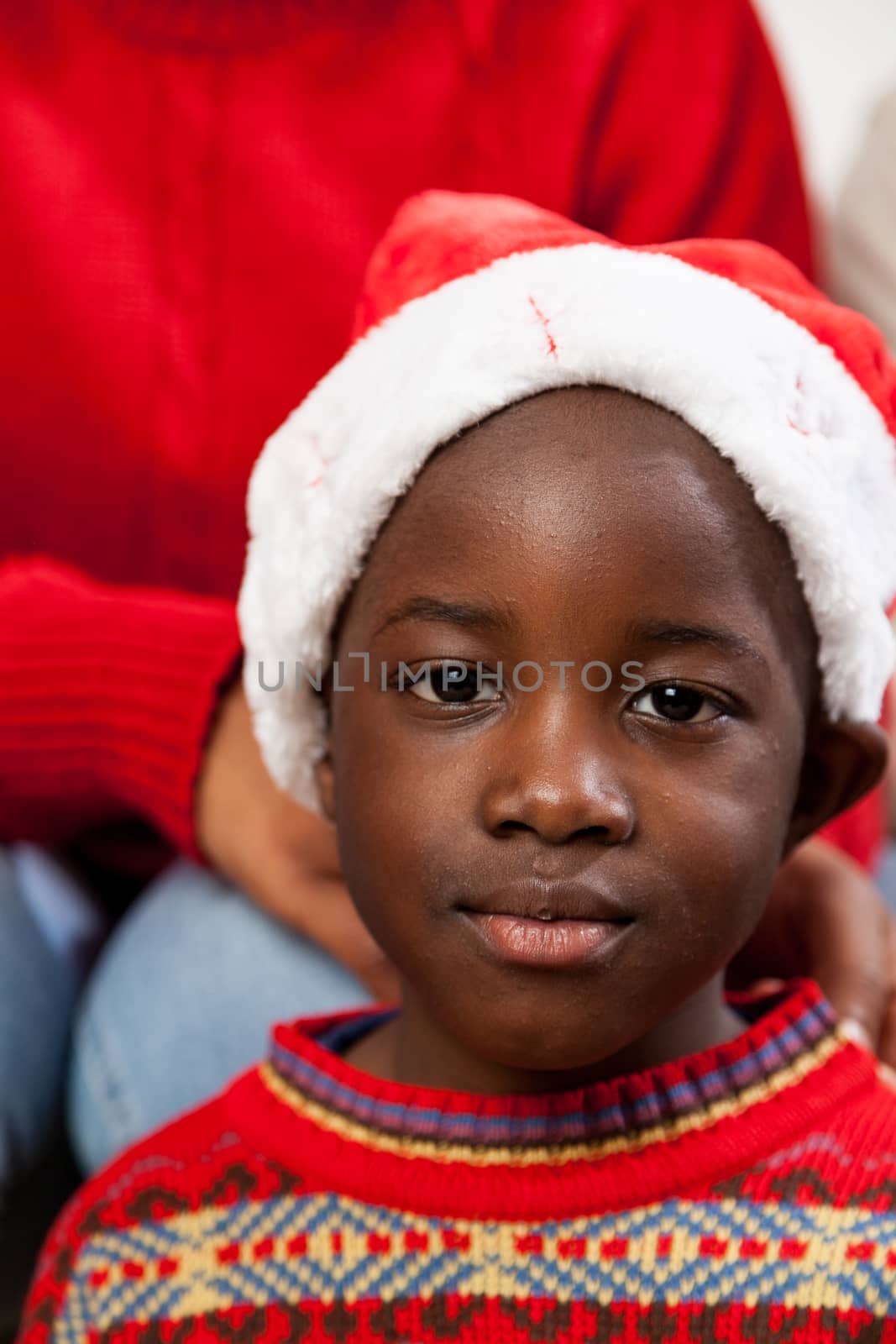 4-6, african, at, black, boy, camera, celebrating, celebration, cheerful, child, children, christmas, color, colour, elementary, gift, happiness, happy, hat, holding, holiday, home, indoors, inside, laughing, living, looking, model, old, portrait, property, red, releases, room, sitting, smiling, special, sweater, vertical, white, years