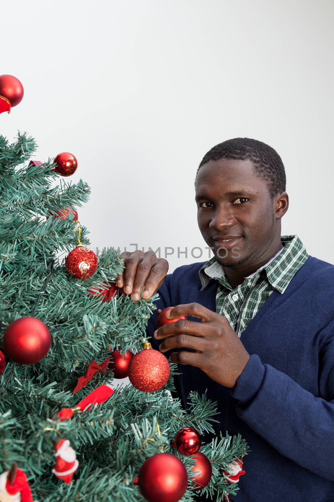 30-35, adult, african, background, balls, beautiful, black, celebration, cheerful, child, christmas, cute, decoration, festive, festivity, handsome, happy, home, homey, indoors, joyful, lifestyle, living, male, man, model, old, one, person, portrait, property, red, releases, room, smiling, time, tree, vertical, white, xmas, years