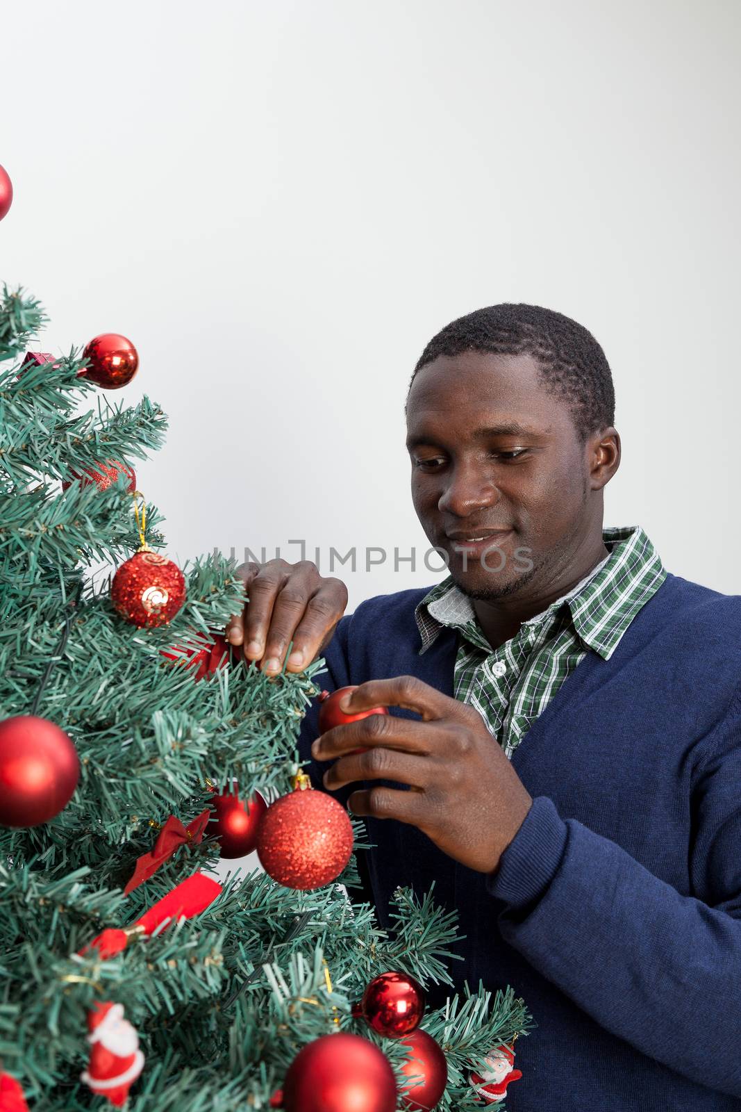 30-35, adult, african, background, balls, beautiful, black, celebration, cheerful, child, christmas, cute, decoration, festive, festivity, handsome, happy, home, homey, horizontal, indoors, joyful, lifestyle, living, male, man, model, old, one, person, portrait, property, red, releases, room, smiling, time, tree, white, xmas, years