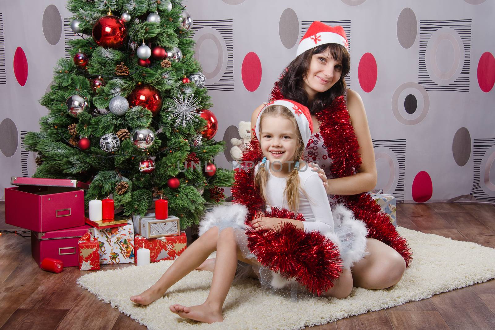 Mum and daughter lie on the five-year rug Christmas tree