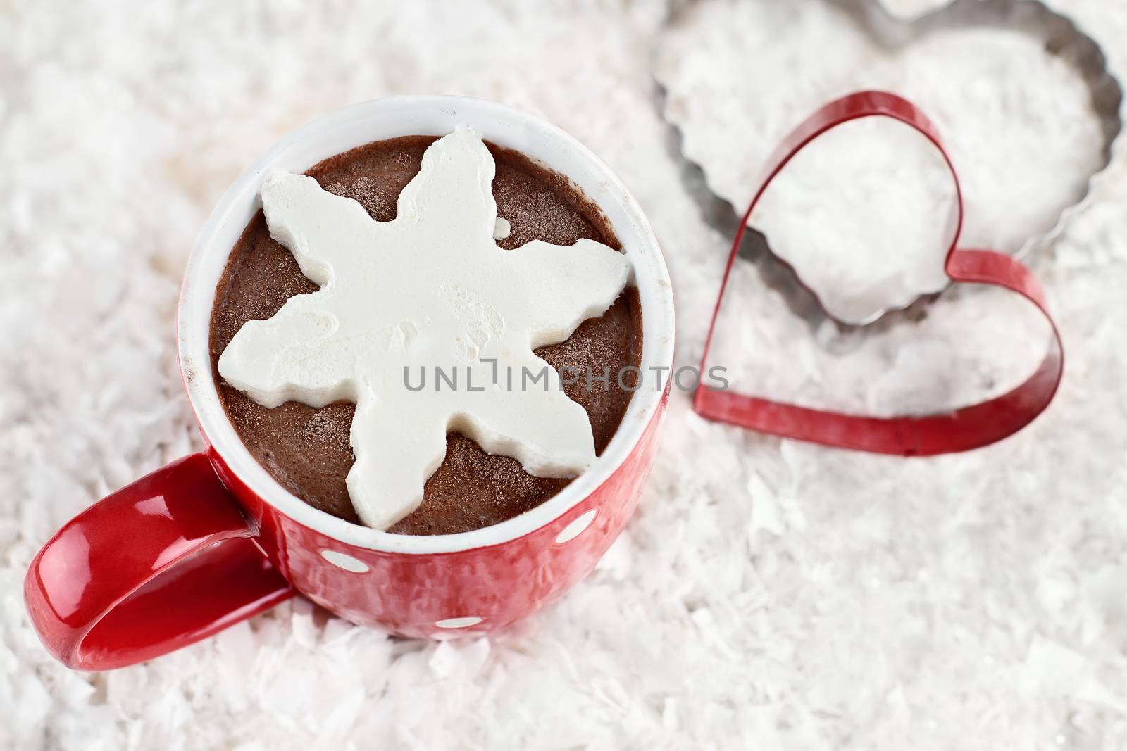 Above shot of a vibrant red cup of hot chocolate with snow flake shape of whipped cream. Extreme shallow depth of field.