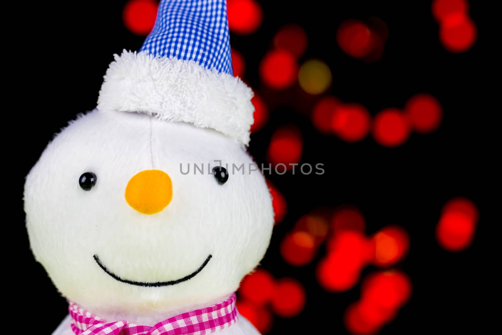 Snowman on a wooden green and red blurred light