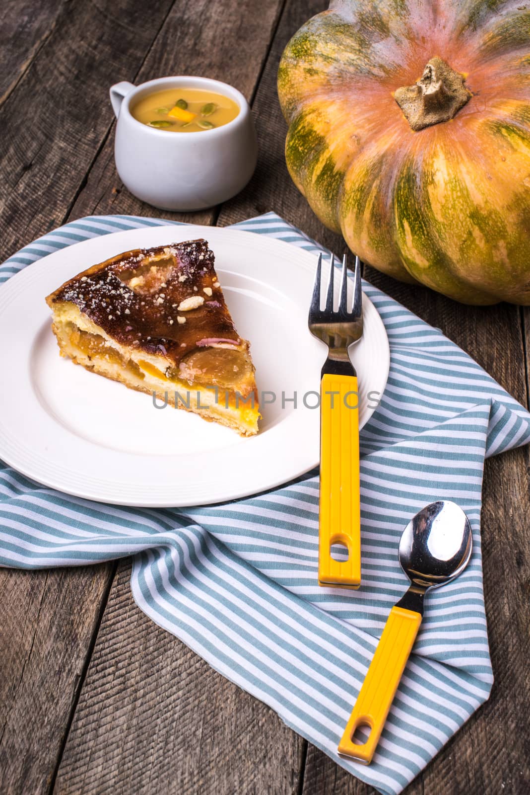piece of Pumpkin pie with mousse on wood in Rustic style