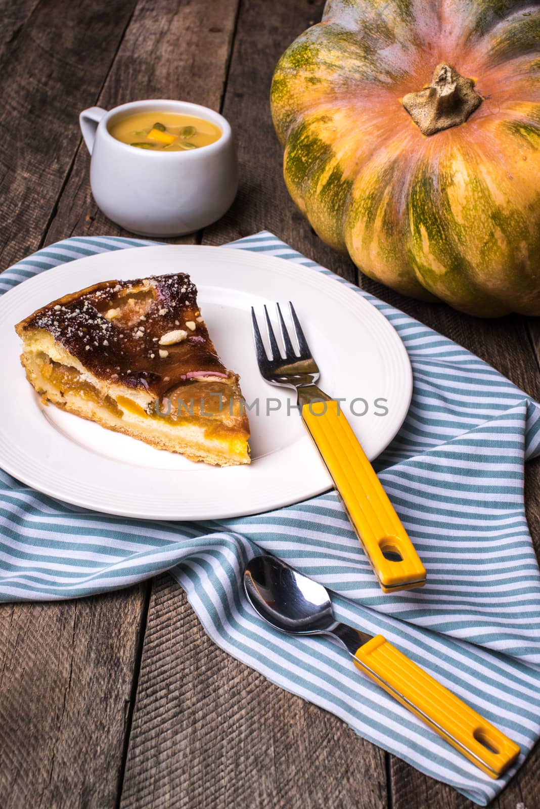 Pumpkin pie piece with cream soup on wood in Rustic style