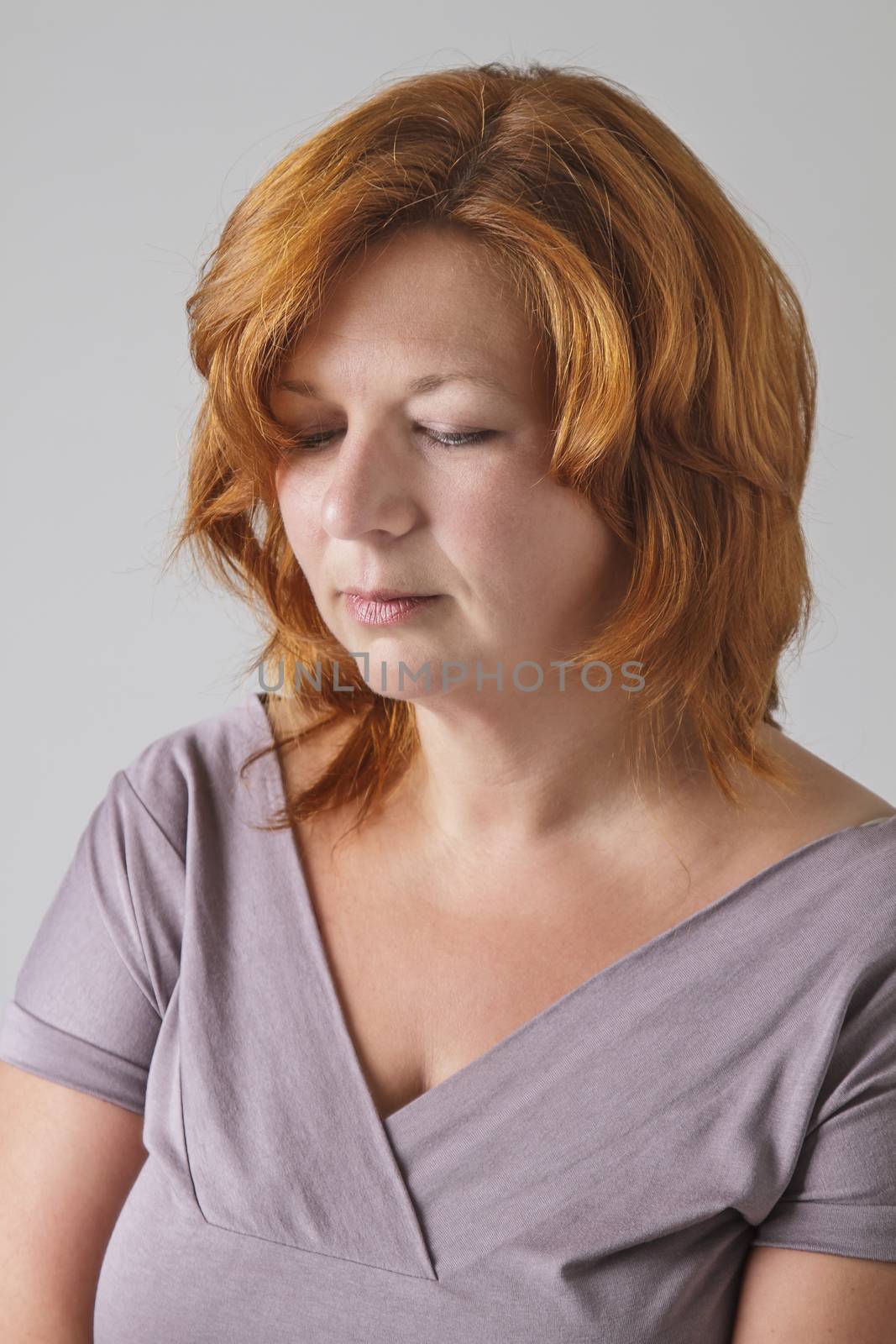 woman in her forties with red hair and her eyes closed
