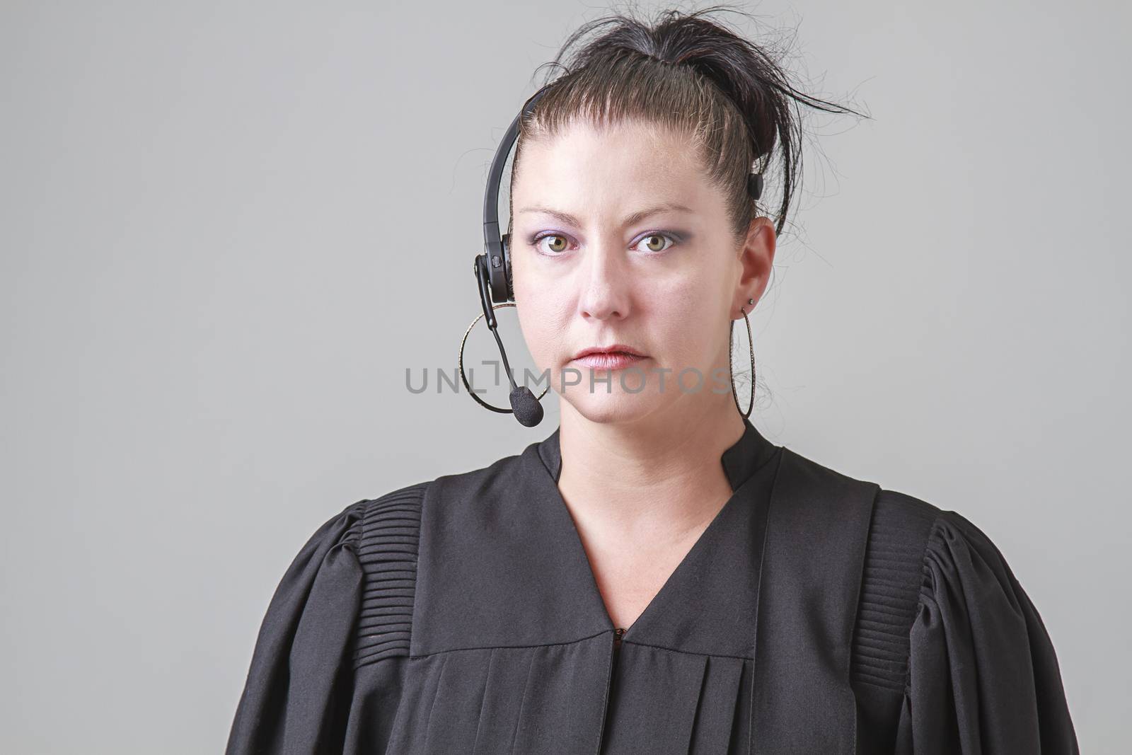 thirty something woman, wearing a preacher robe and phone headset