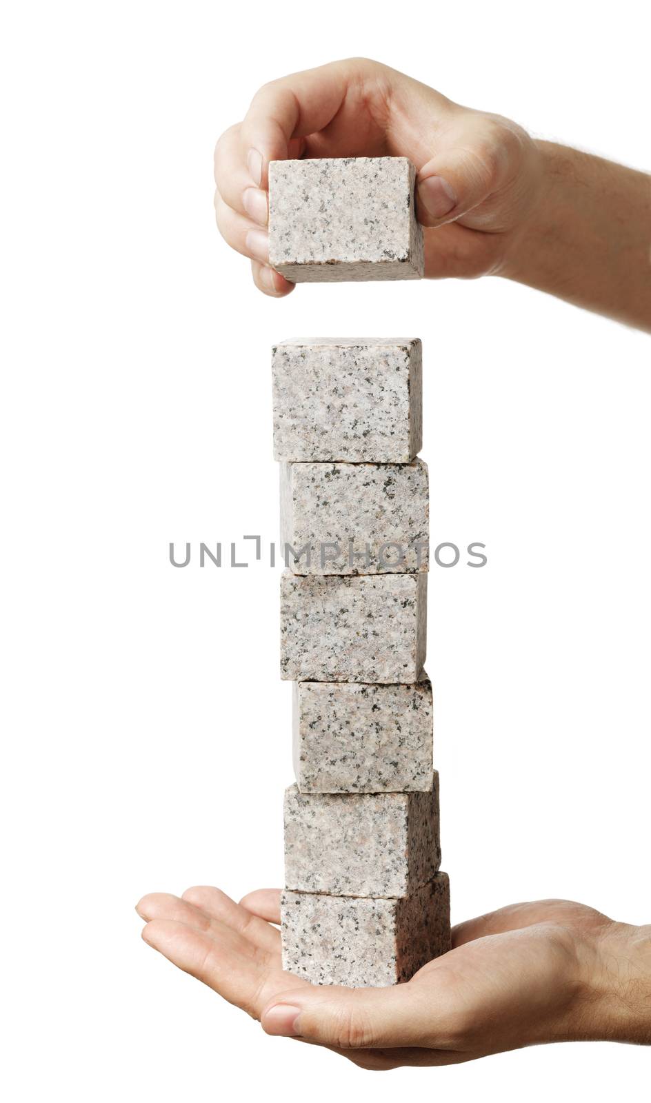 Man stacking granite rock blocks in his hand.