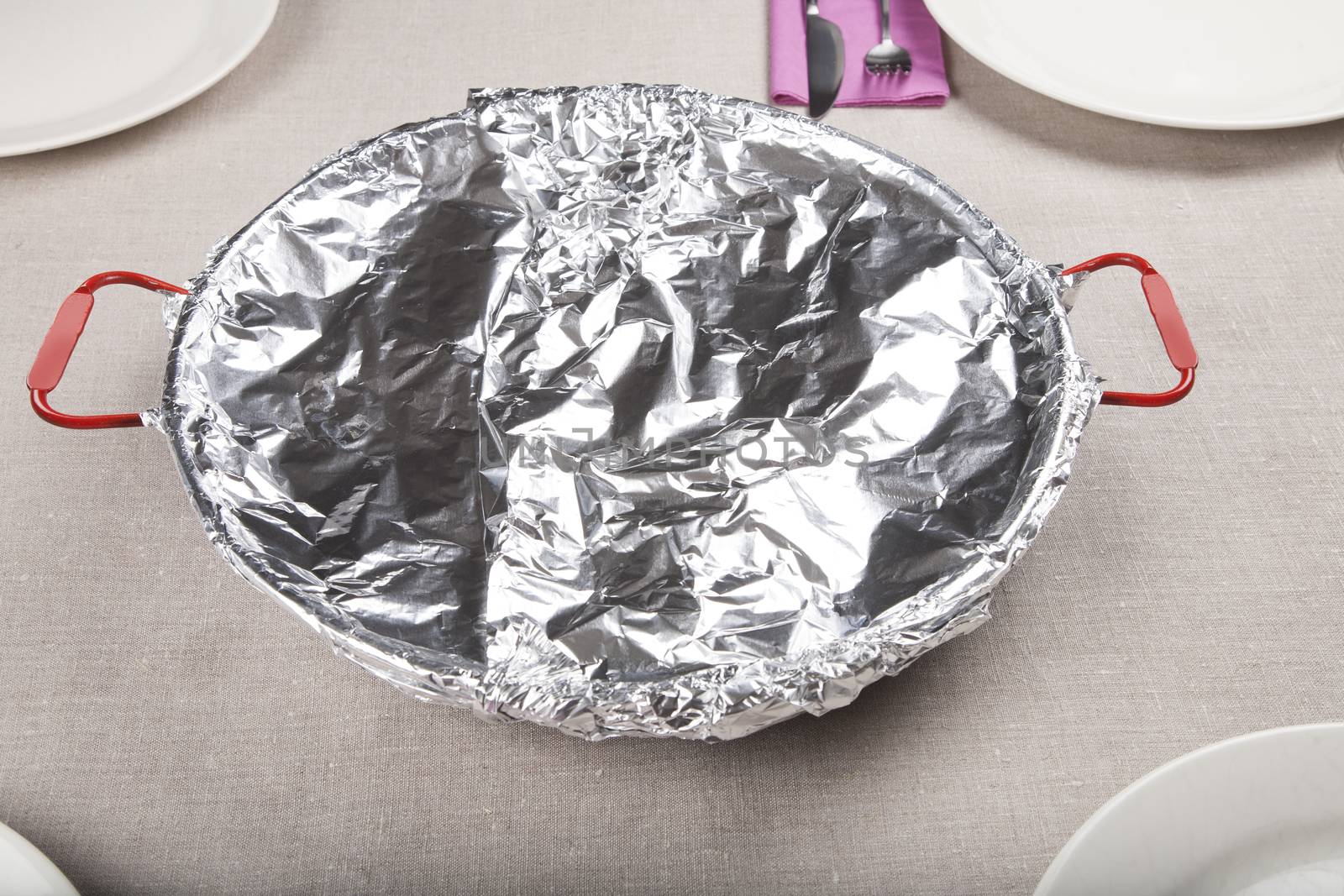 spanish paella in paellera pan wrapped with foil