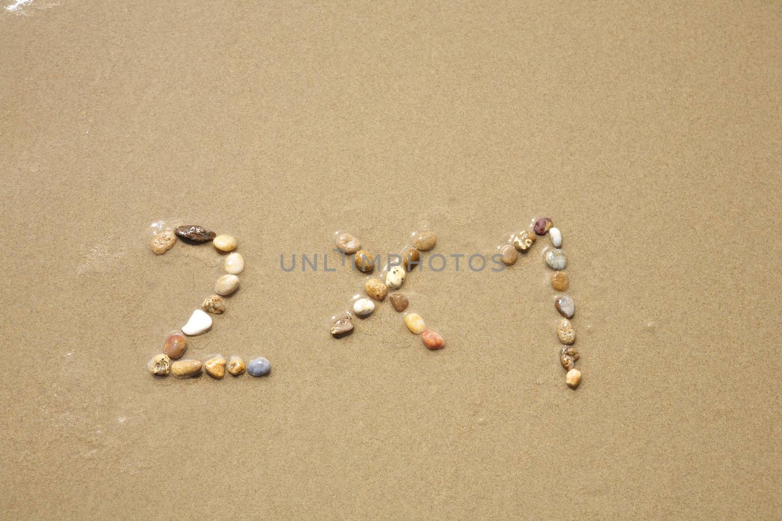 2x1 discount word writing with small stones on sand beach ground