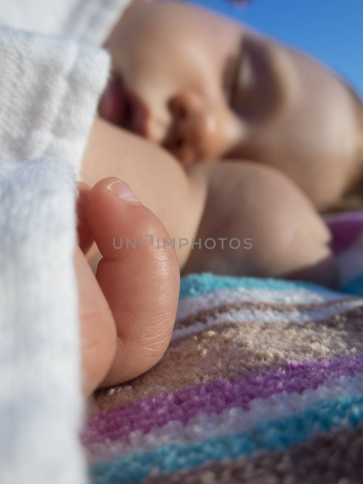 close-up finger baby and face sleeping on towel