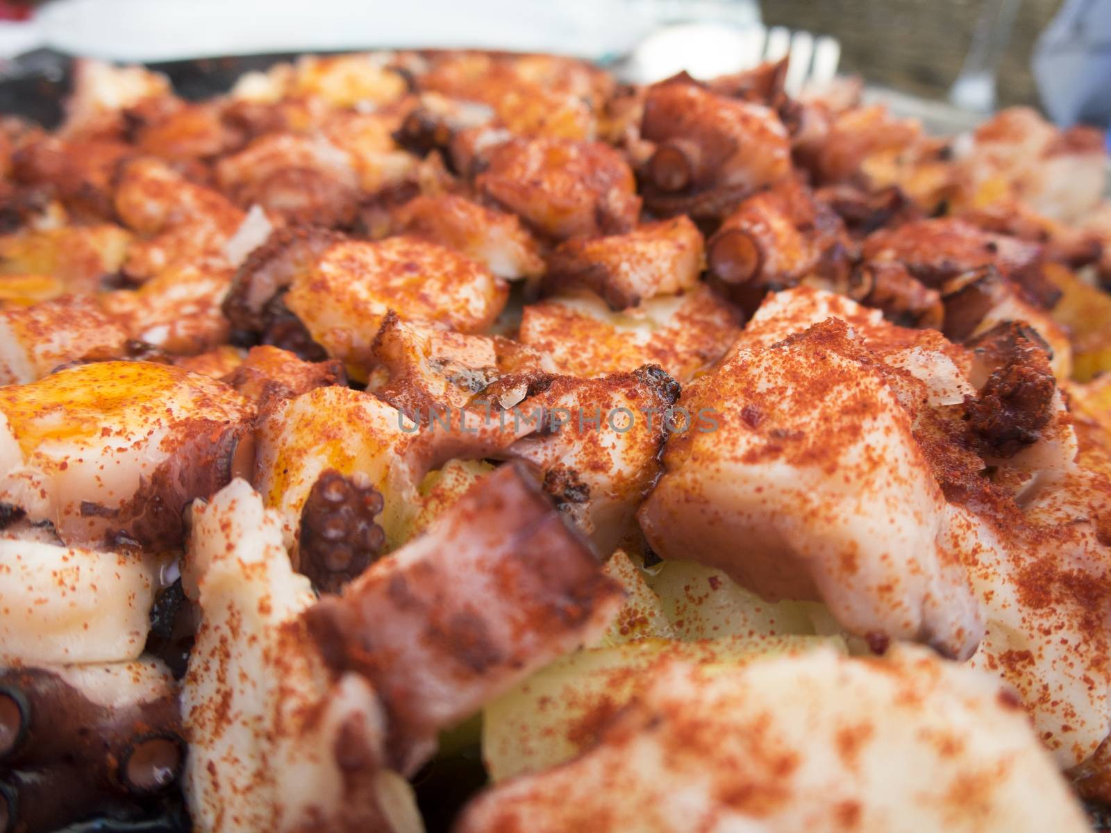 black dish with octopus and potatoes cooked like Galician style with paprika