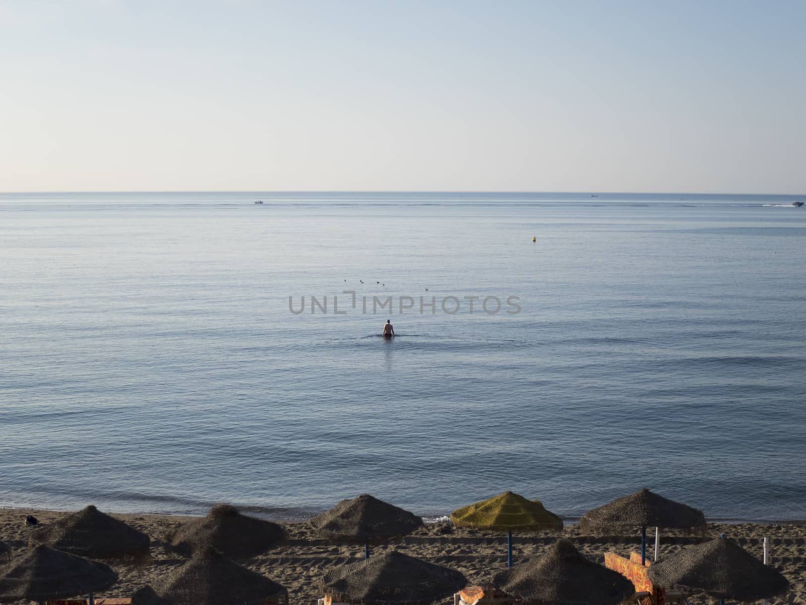 man walking water Mediterranean Sea in Benalmadena beach Andalucia Spain at sunrise