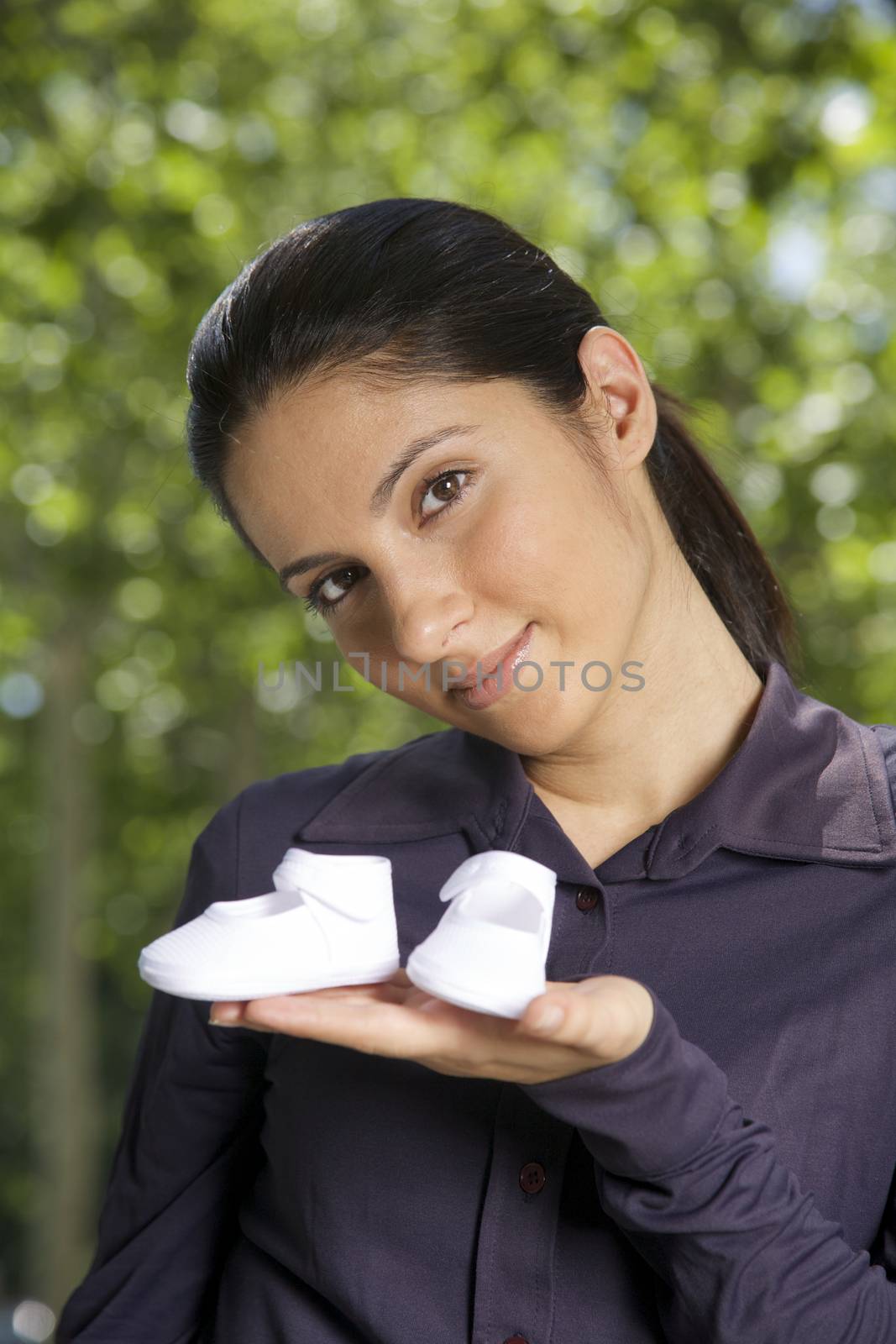 woman with booties on her hand on green natural background
