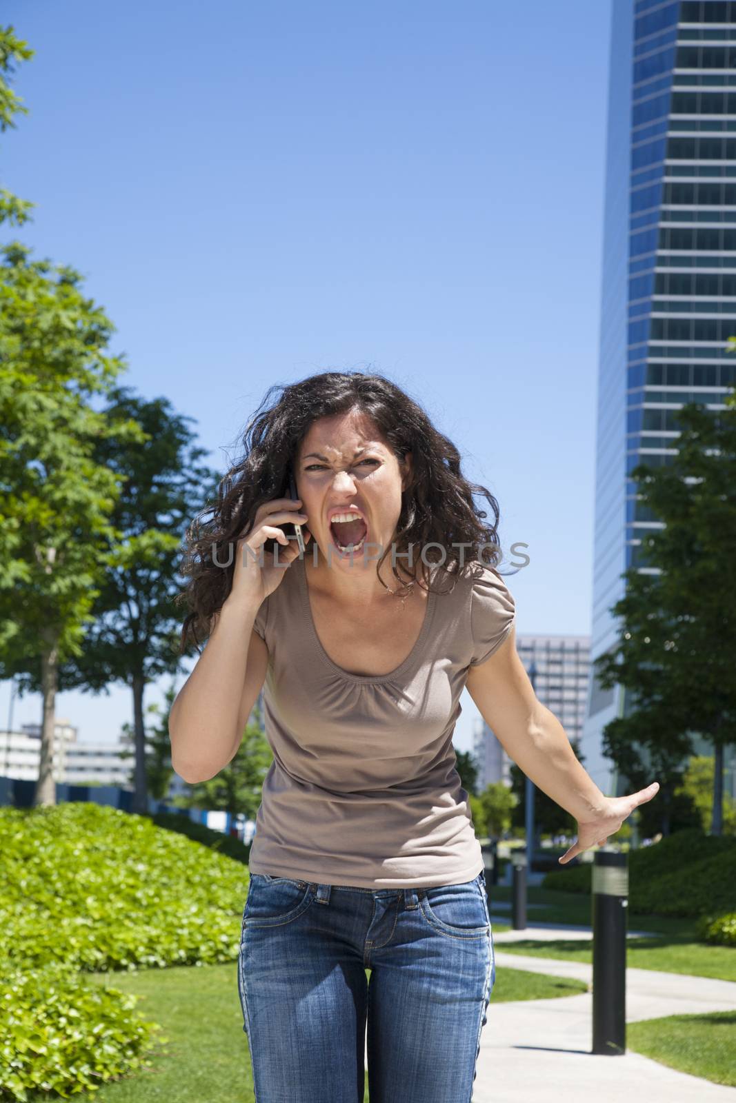 portrait of angry woman shouting to mobile at street