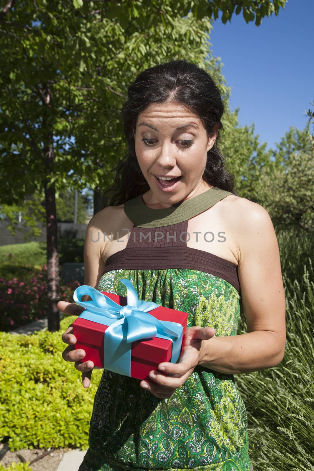 happy female with gift box in exterior background