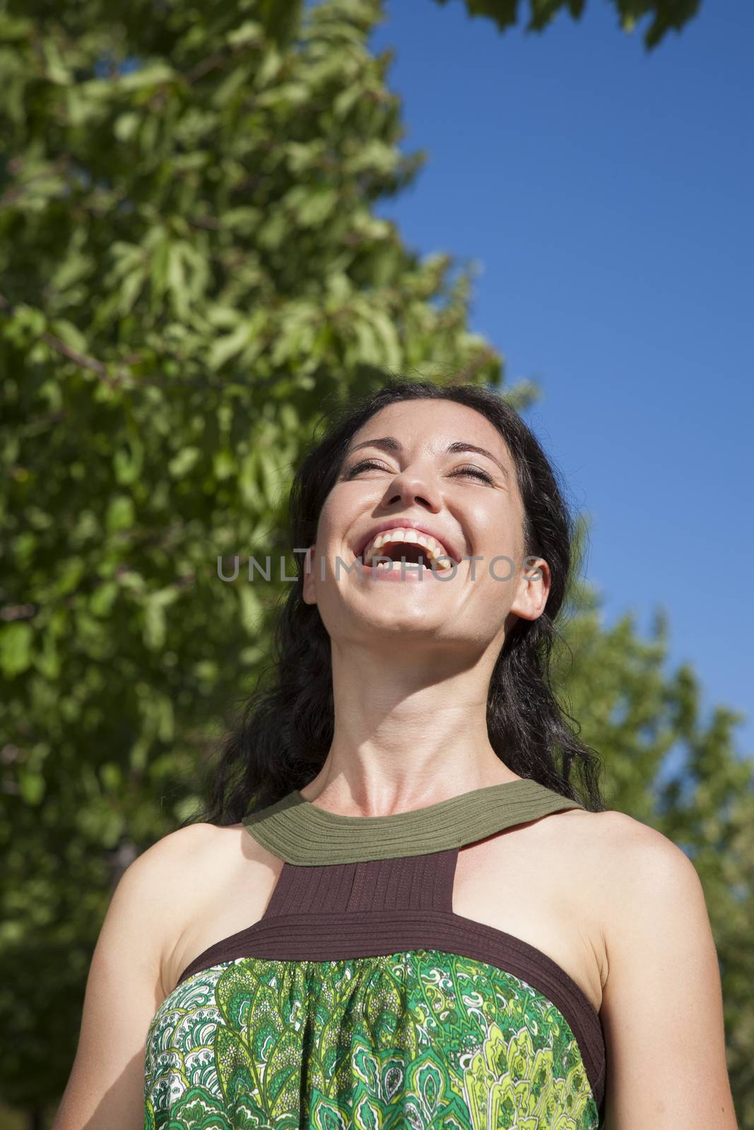 pretty brunette woman laughing at exterior background
