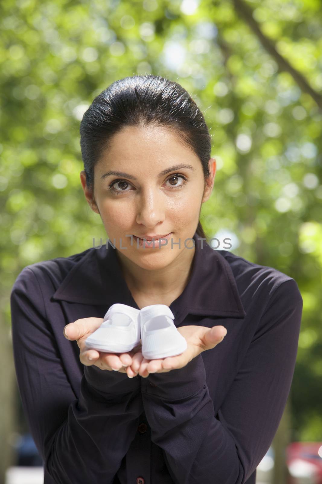 woman with booties on her hand on green natural background
