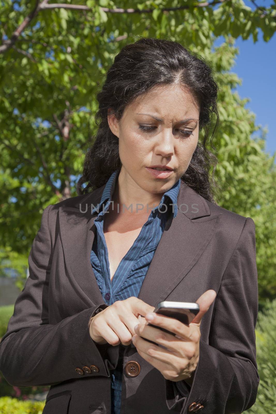 businesswoman reading smartphone in exterior background