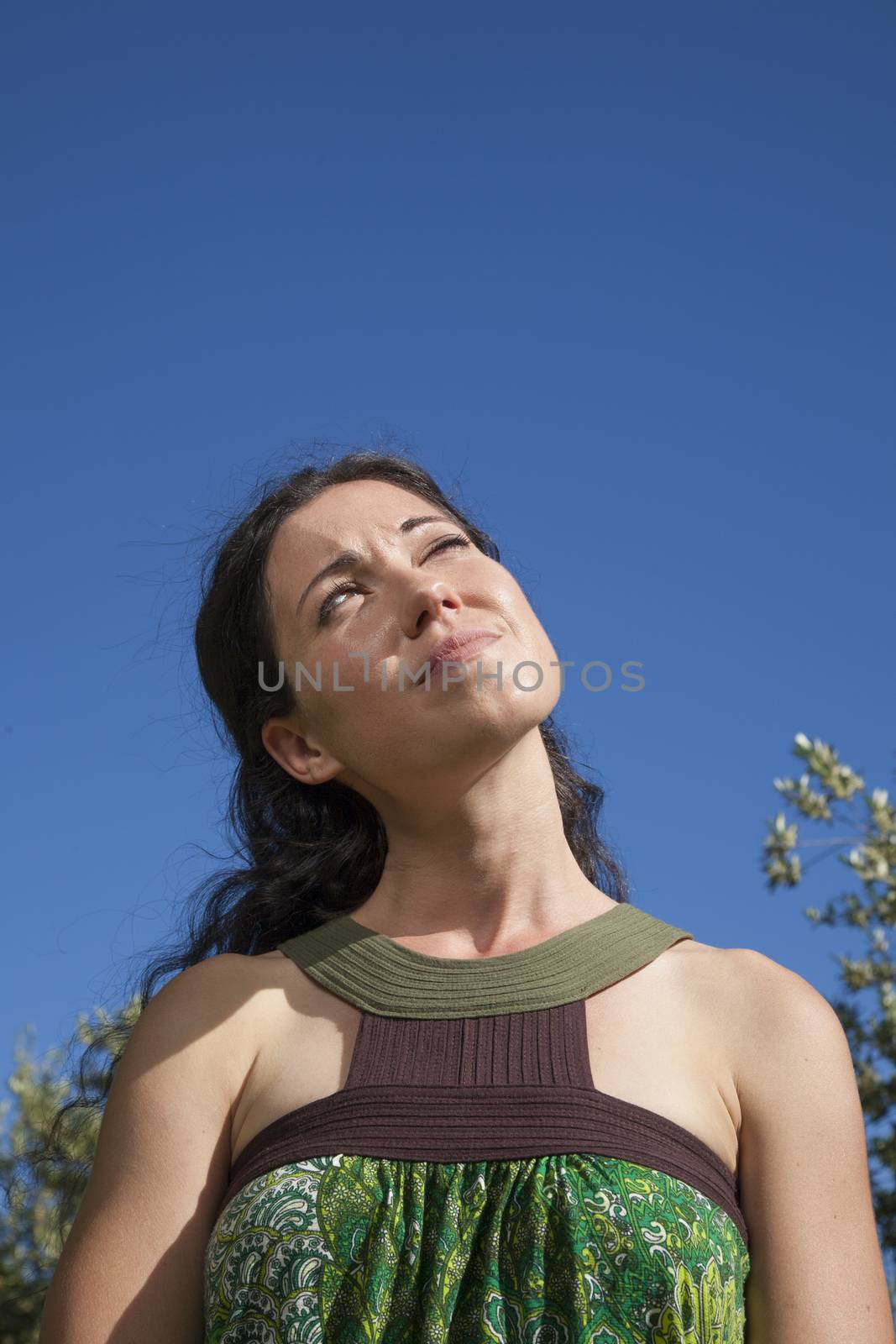 pretty brunette woman thinking in exterior background