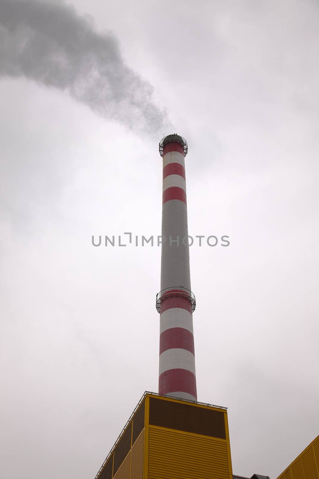 Industrial chimney smoking in the cloudy weather