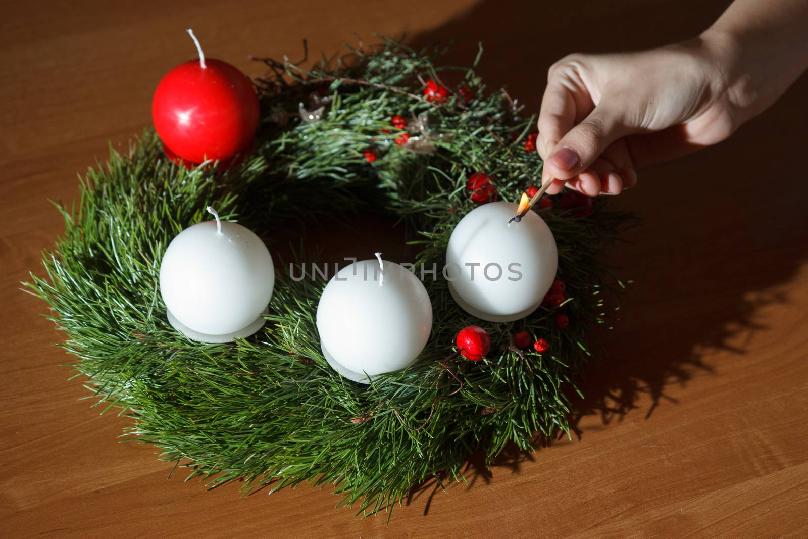 woman's hand lit the first candle of the Advent wreath