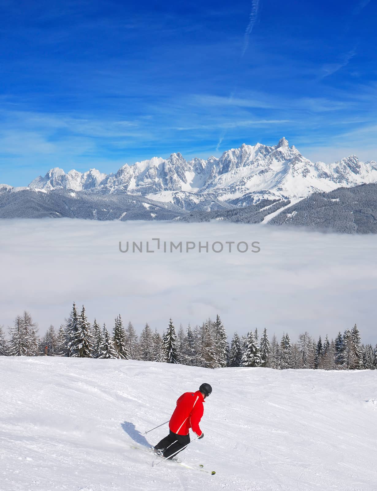 Separate skier on the slopes, riding above the clouds