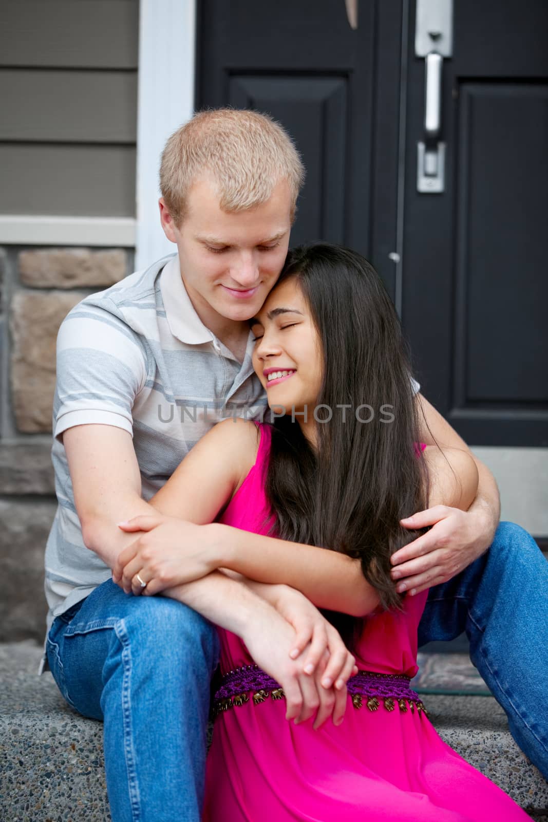 Young,  happy diverse couple sitting together outdoors