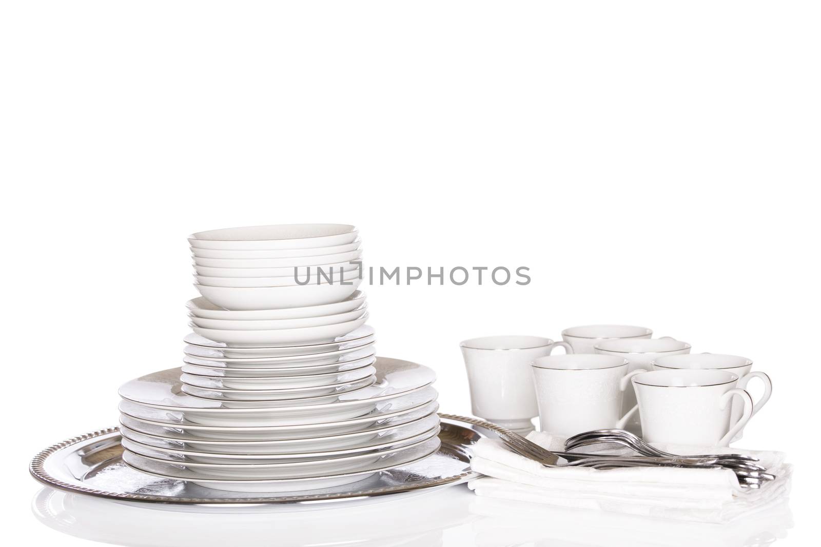 Dinnerware, stacks of white chinaware on silver platter