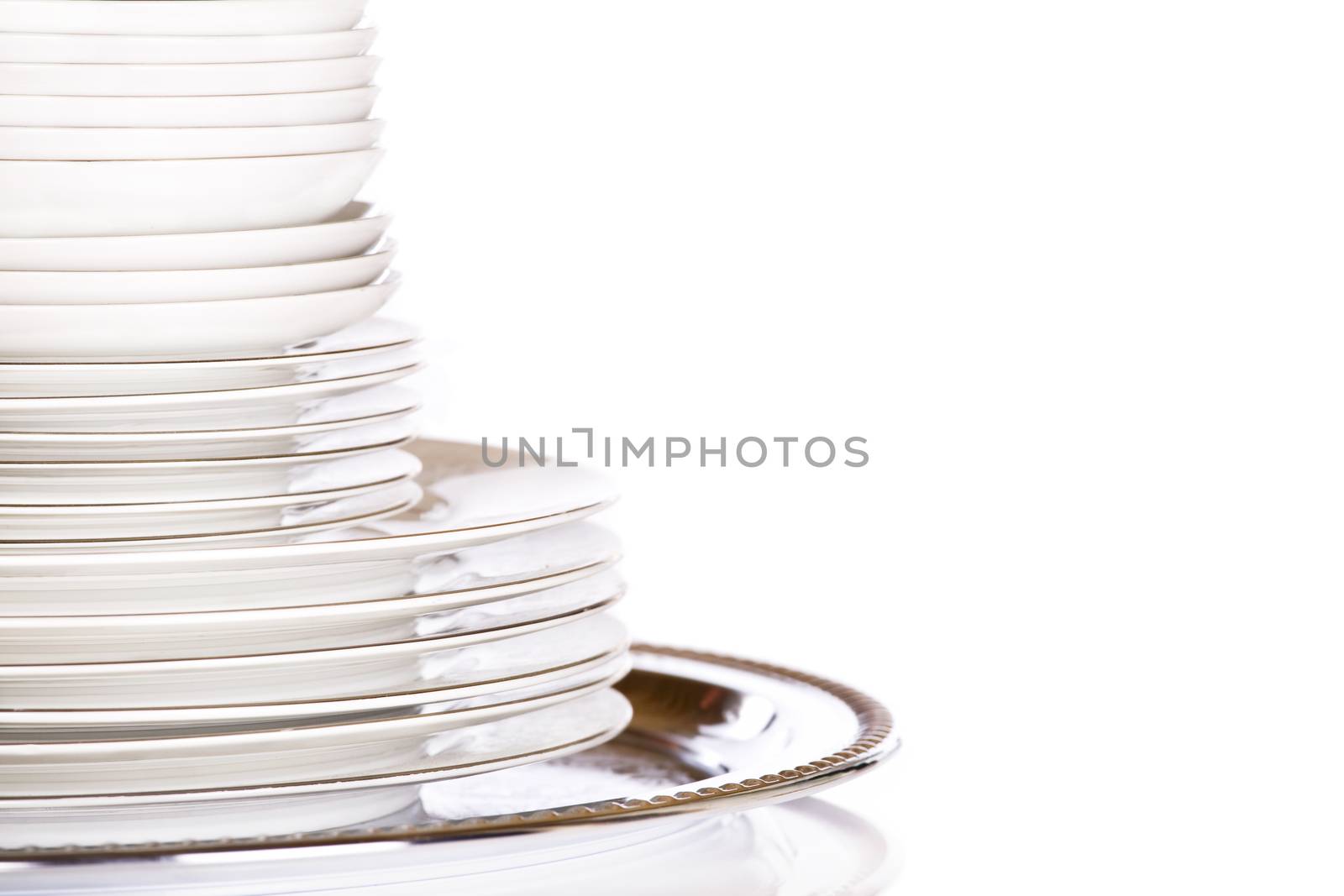 Stack of white dishes on silver platter by jarenwicklund