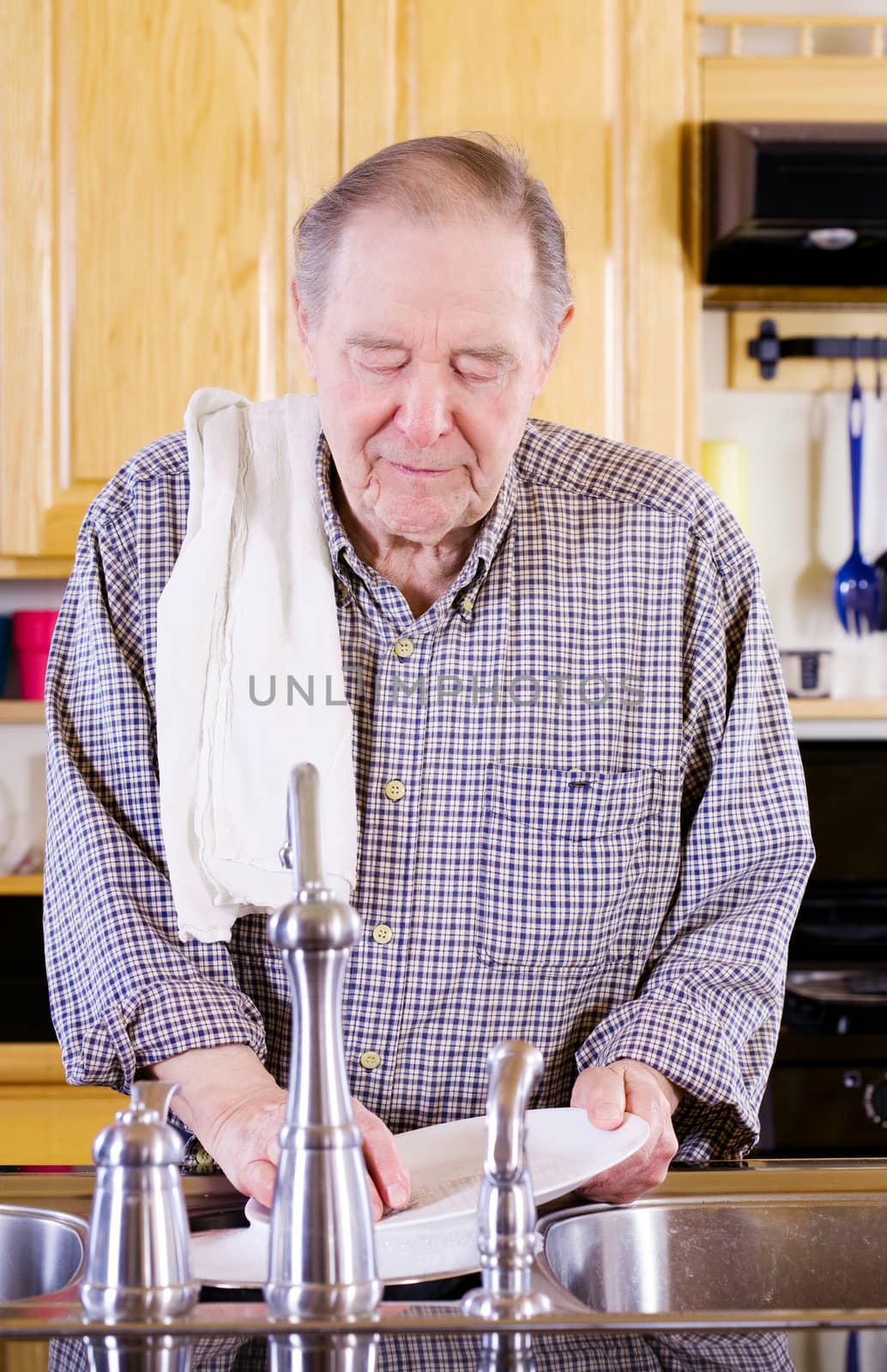 Elderly man washing dishes by jarenwicklund