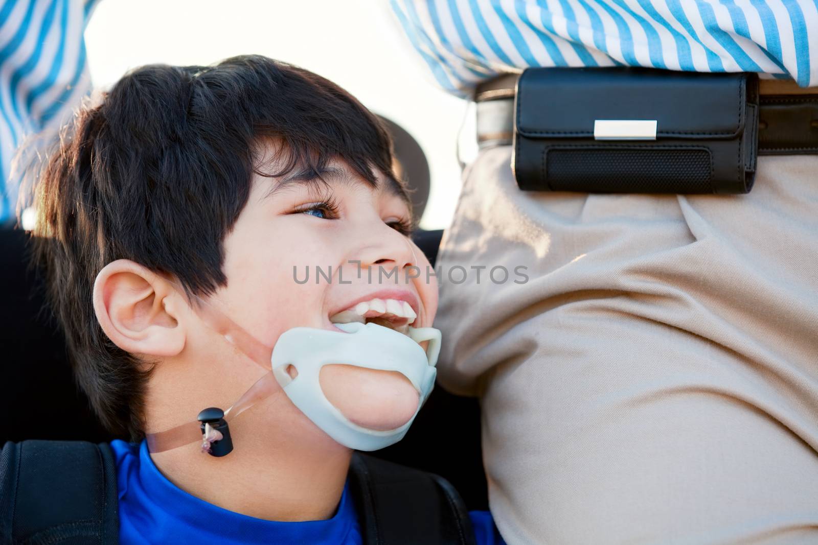 Disabled little boy in wheelchair next to father by jarenwicklund