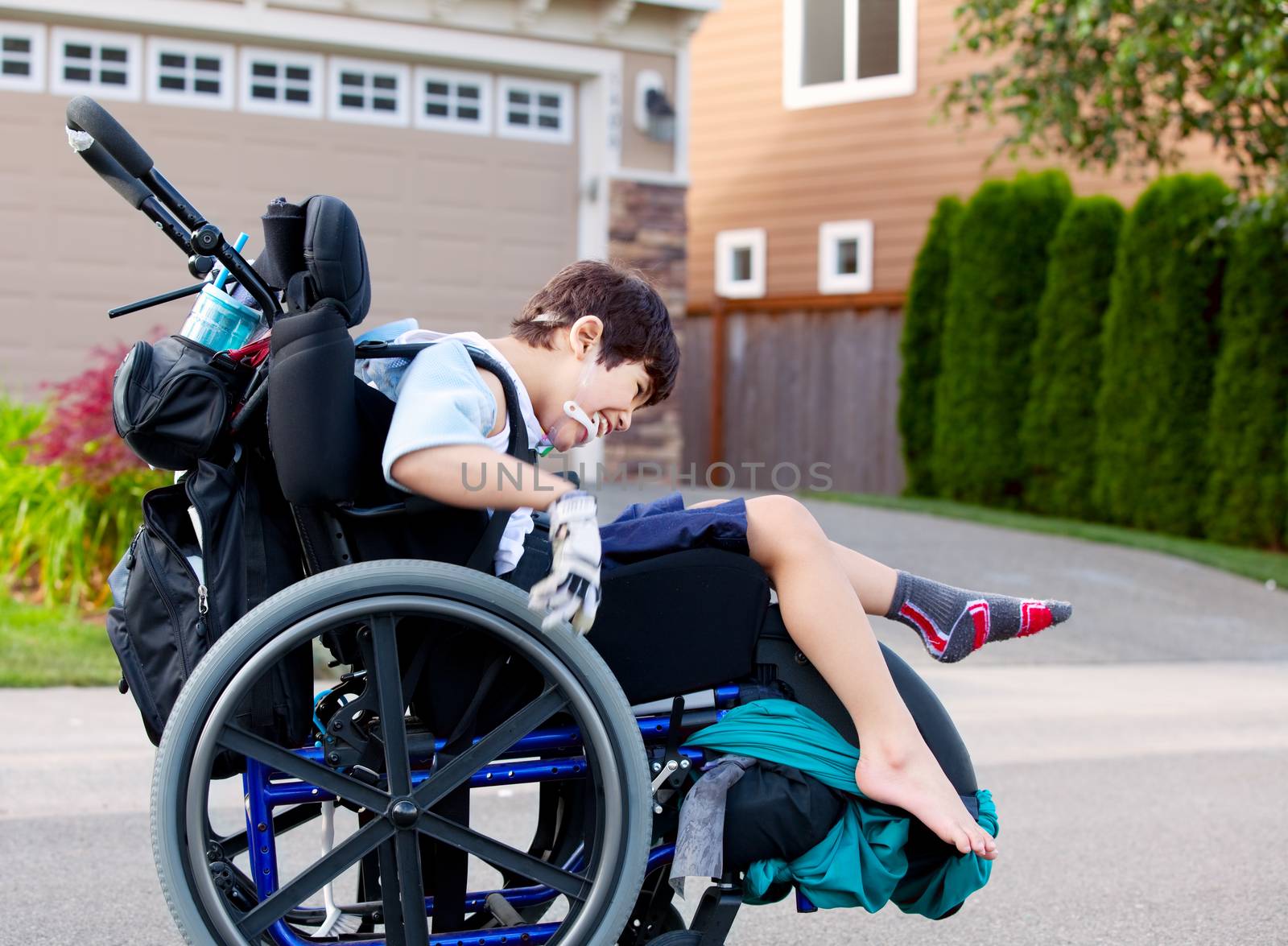 Happy little disabled boy outdoors in wheelchair by jarenwicklund