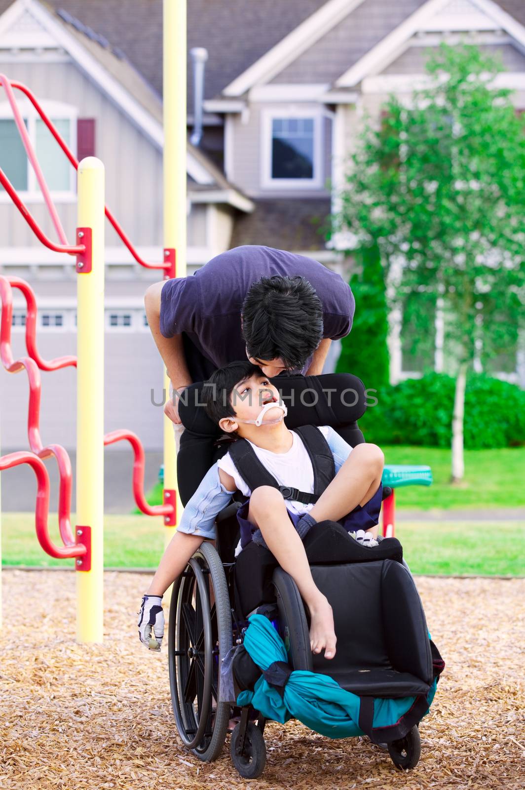 Disabled boy in wheelchair with big brother at park by jarenwicklund