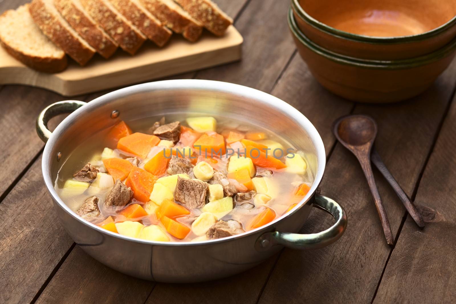 Pot filled with traditional Hungarian soup called Gulyasleves made of beef, potato, carrot, onion, csipetke (homemade pasta) and seasoned with salt and paprika (Selective Focus, Focus one third into the soup)