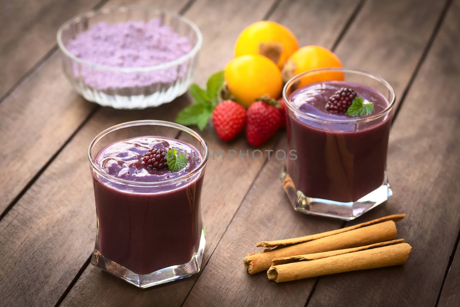 Ecuadorian traditional thick drink called Colada Morada, prepared by cooking purple corn flour and different fruits (for example strawberry, pineapple, naranjilla, grape, babaco, blackberry, etc) and seasoned with panela (cane sugar), cinnamon, allspice and cloves (Selective Focus, Focus on the blackberry on the left drink)