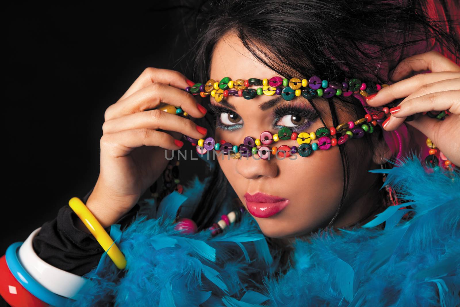Woman holding colorful necklace of beads on his face.