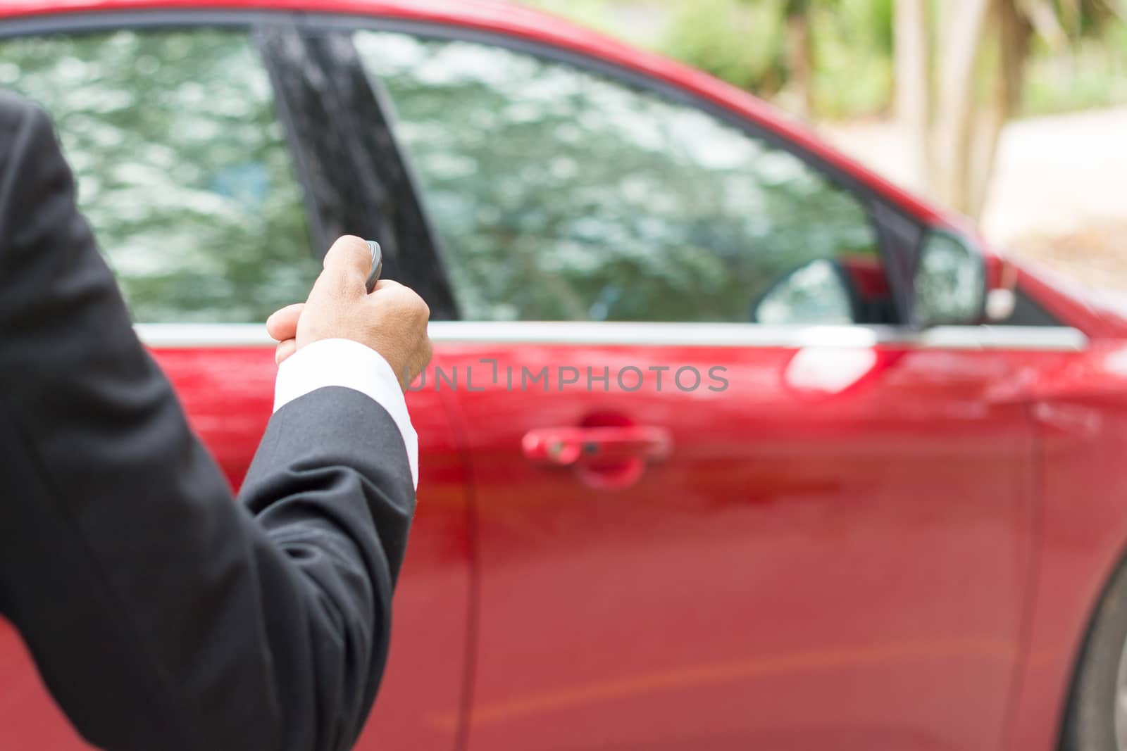 business man use remote control red car