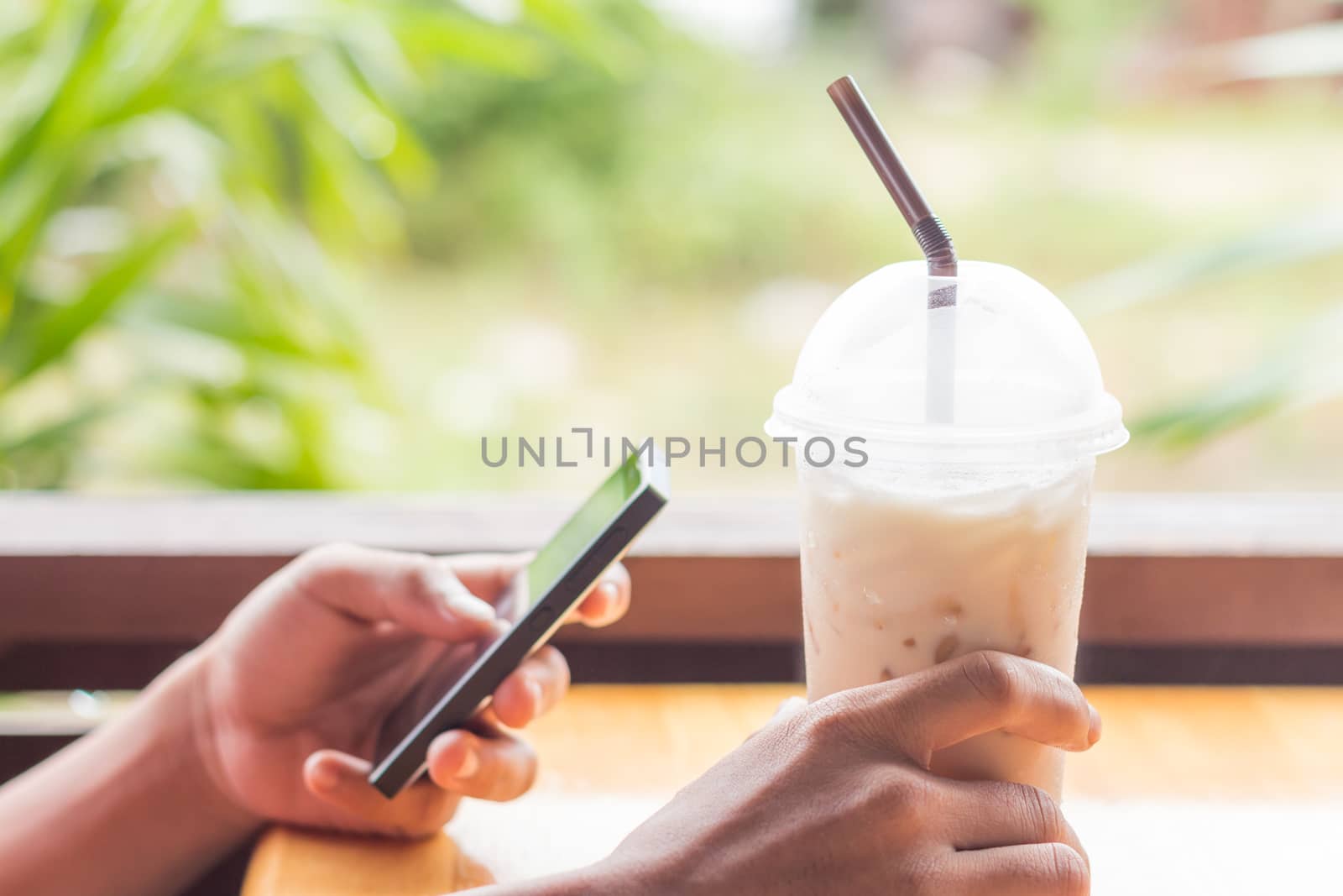 hand hold coffee and use smart phone