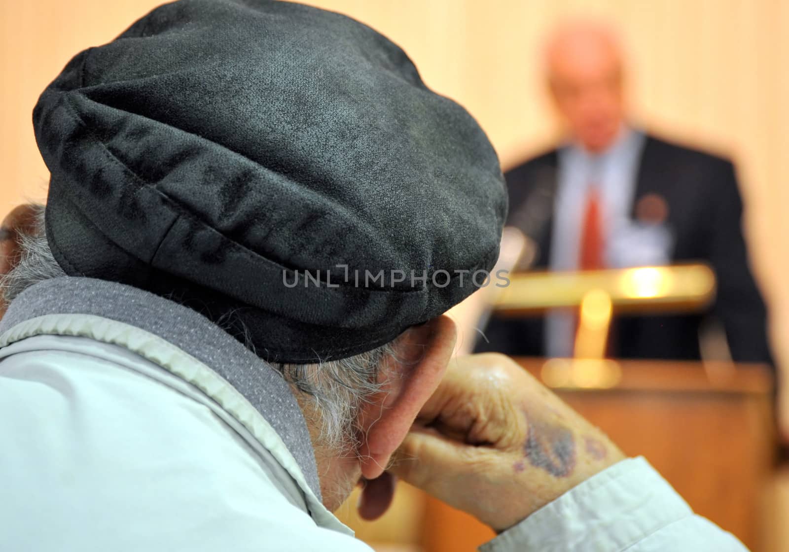 Male voter attending a political debate indoors.